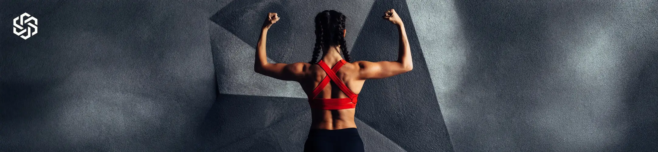 Strong woman flexing back muscles while wearing athletic workout clothing