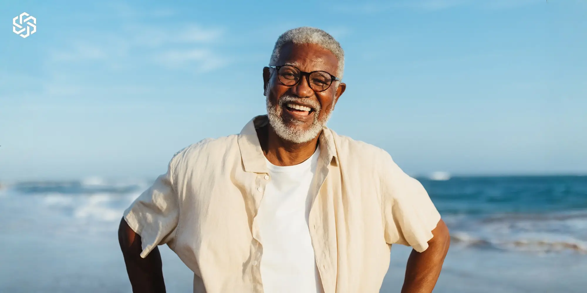 Smiling older man standing on a beach, showing confidence and improved health after weight loss