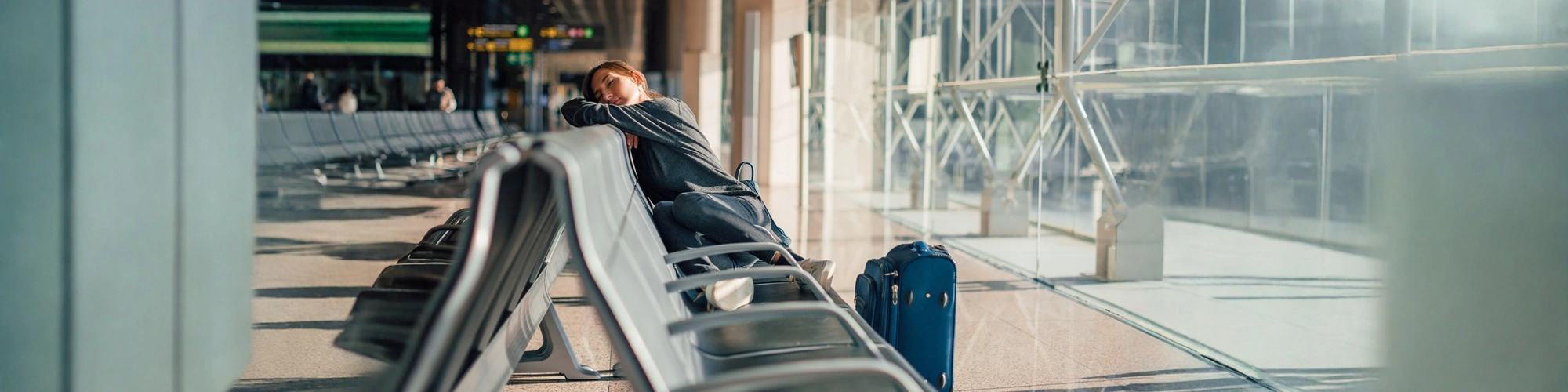 traveler with jet lag fatigue at airport needing IV therapy for hydration and energy recovery