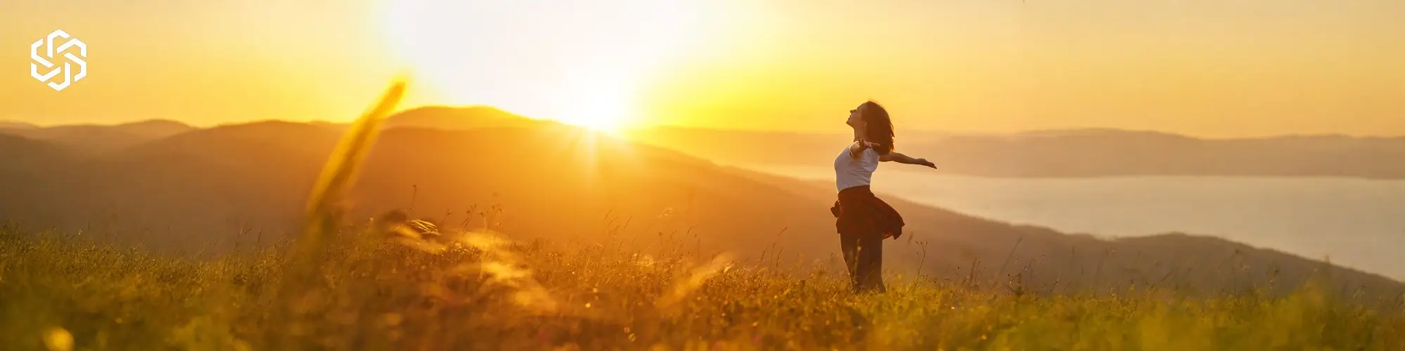Woman enjoying sunrise in an open field representing wellness and Vitamin D Injection Therapy benefits at Lake Forest Regenesis