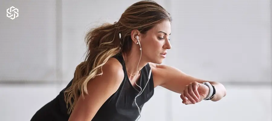 Active woman checking smartwatch during workout on women’s hormone replacement therapy page.
