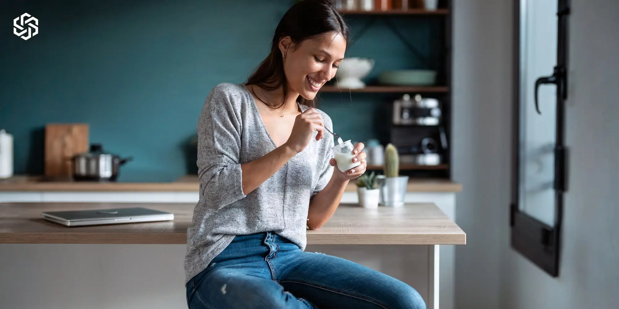 Smiling woman eating a healthy snack in her kitchen