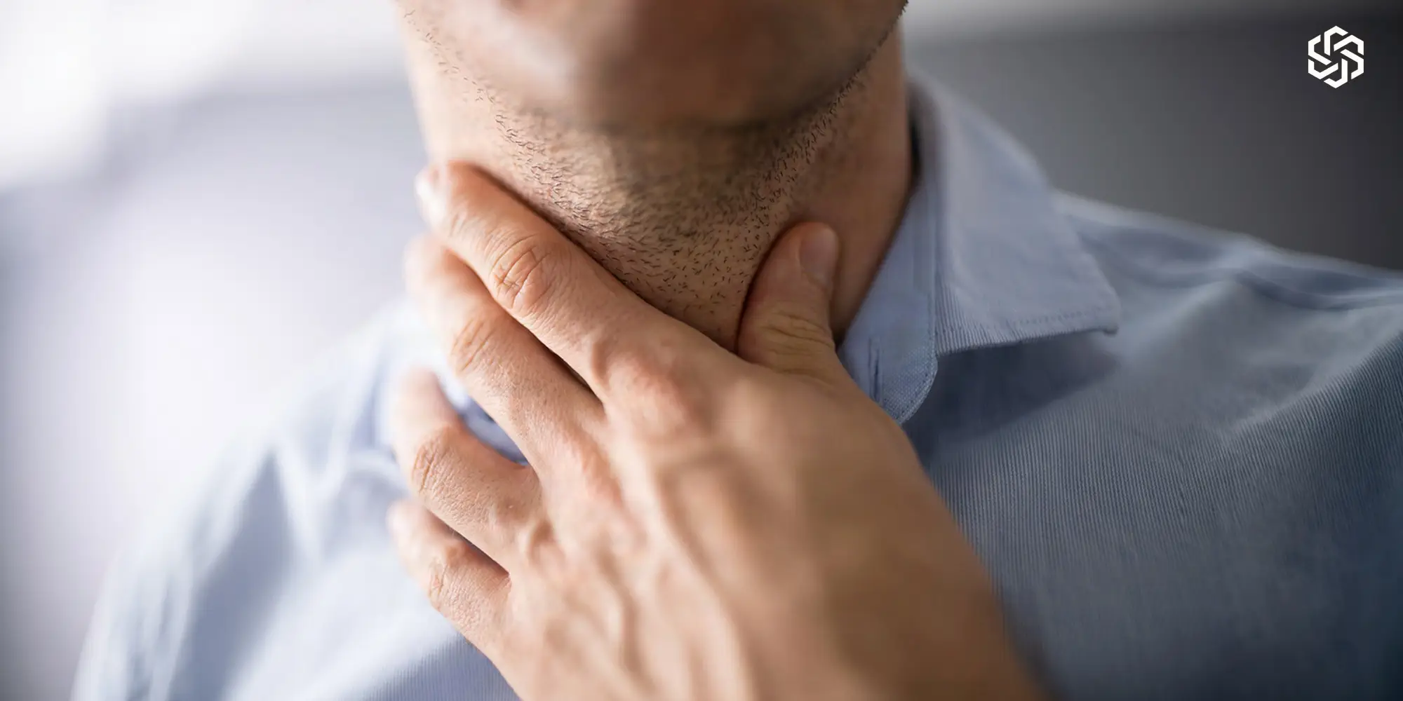 Man touching the front of his neck near the thyroid