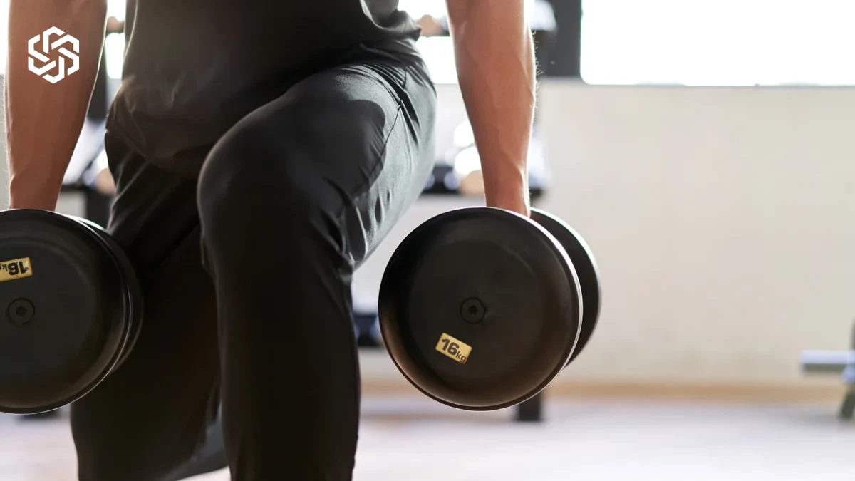 Man lifting dumbbells at the gym to preserve muscle while losing weight