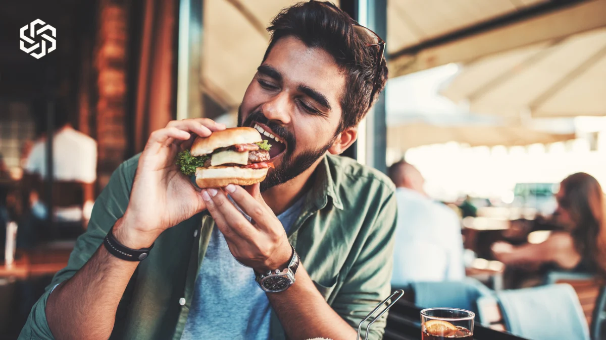 Man eating a burger at a cafe