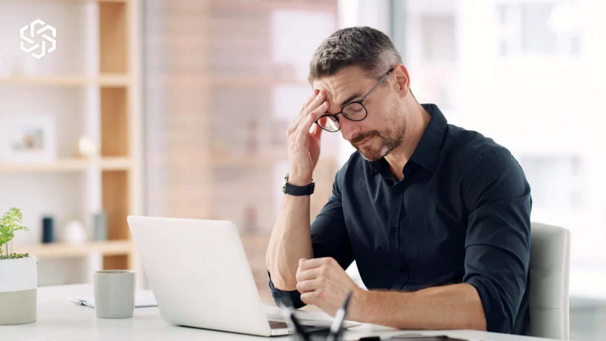 Man with a headache working at his laptop