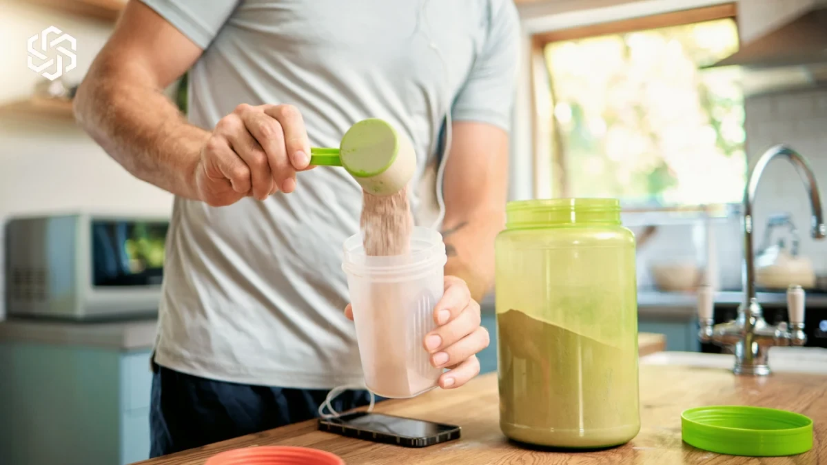 Man adding protein powder to a shake