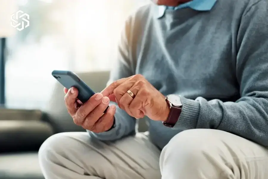 Older man using a smartphone at home