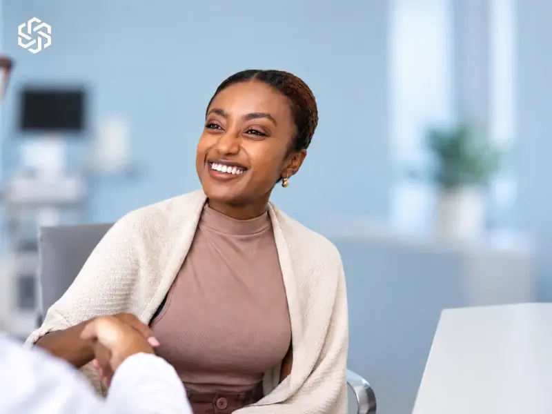 Smiling woman talking with her provider in a bright clinic room