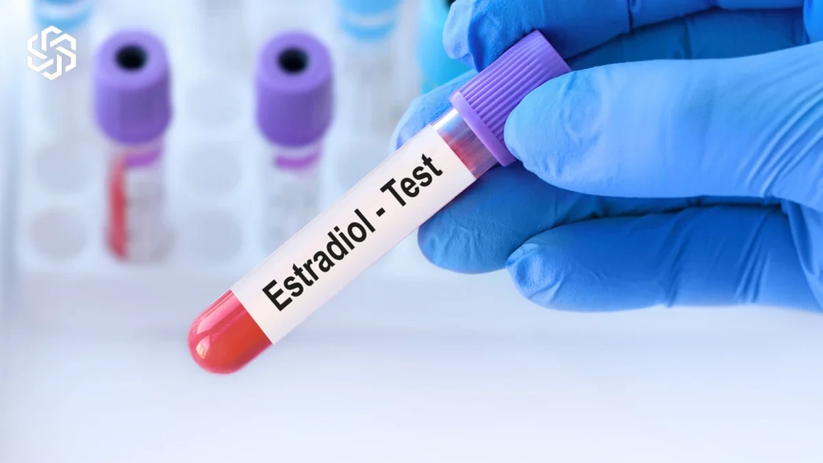 Gloved hand holding an estradiol blood test tube used in estradiol and FSH testing