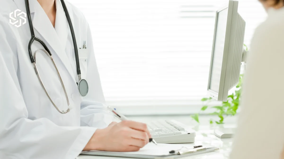 Provider in a white coat filling out forms