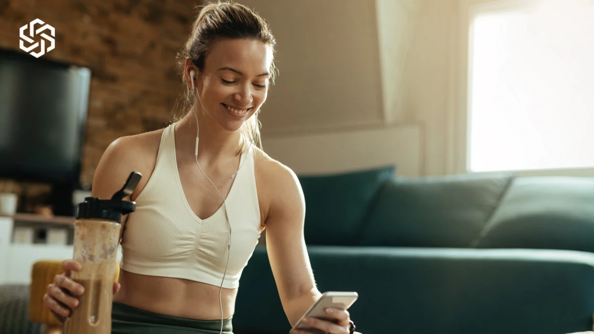 Woman with a smoothie checking her phone