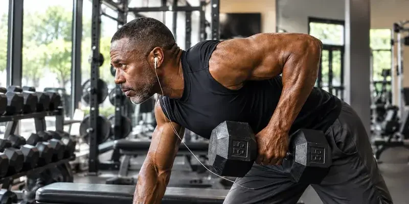 Man doing a dumbbell row in a home gym