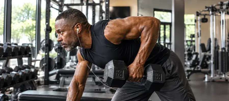 Man doing a dumbbell row in a home gym