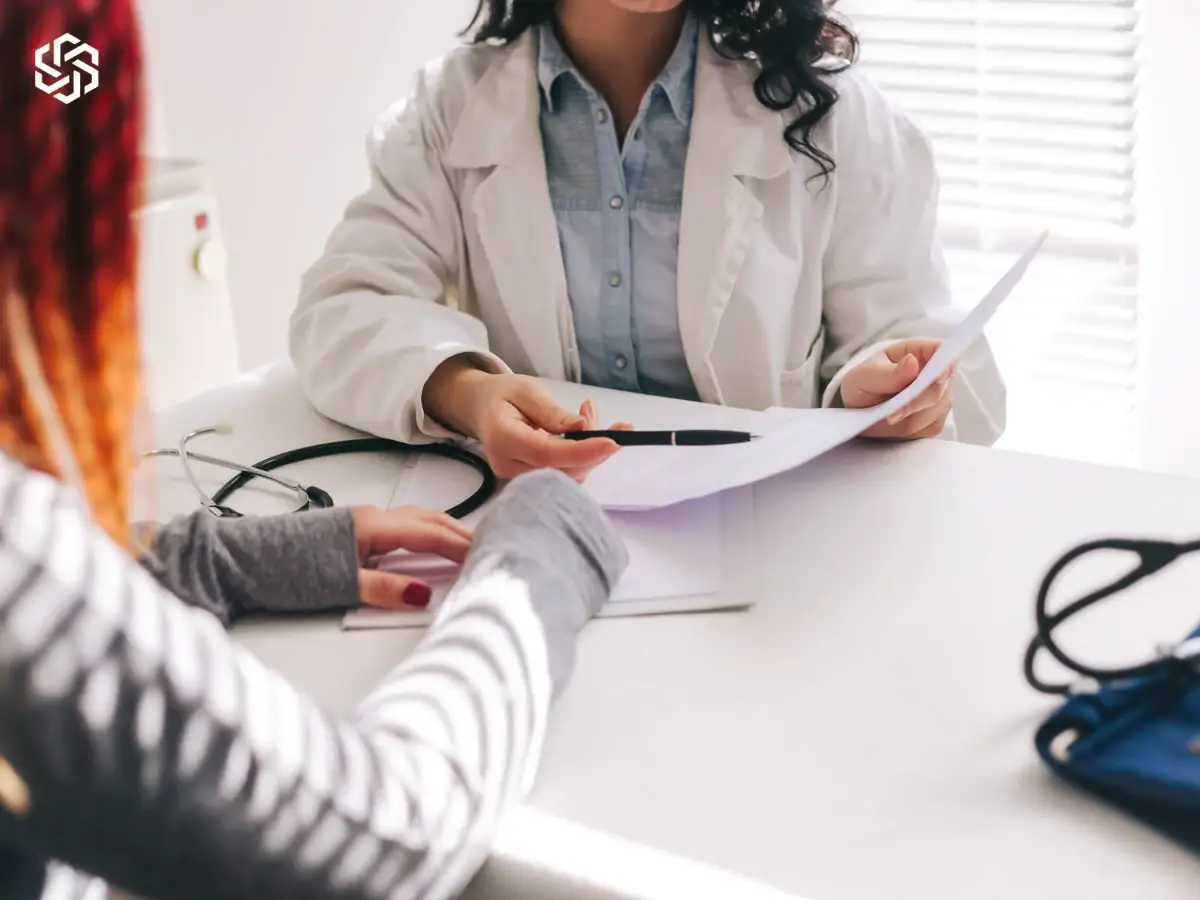 Provider reviewing lab results on paper with a patient