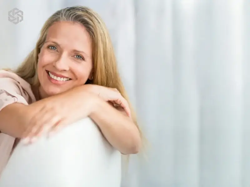 Smiling woman leaning on a chair in a bright room