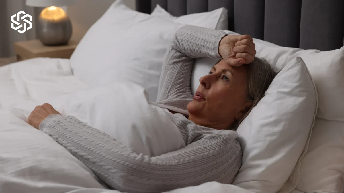 Woman lying awake in bed feeling overheated