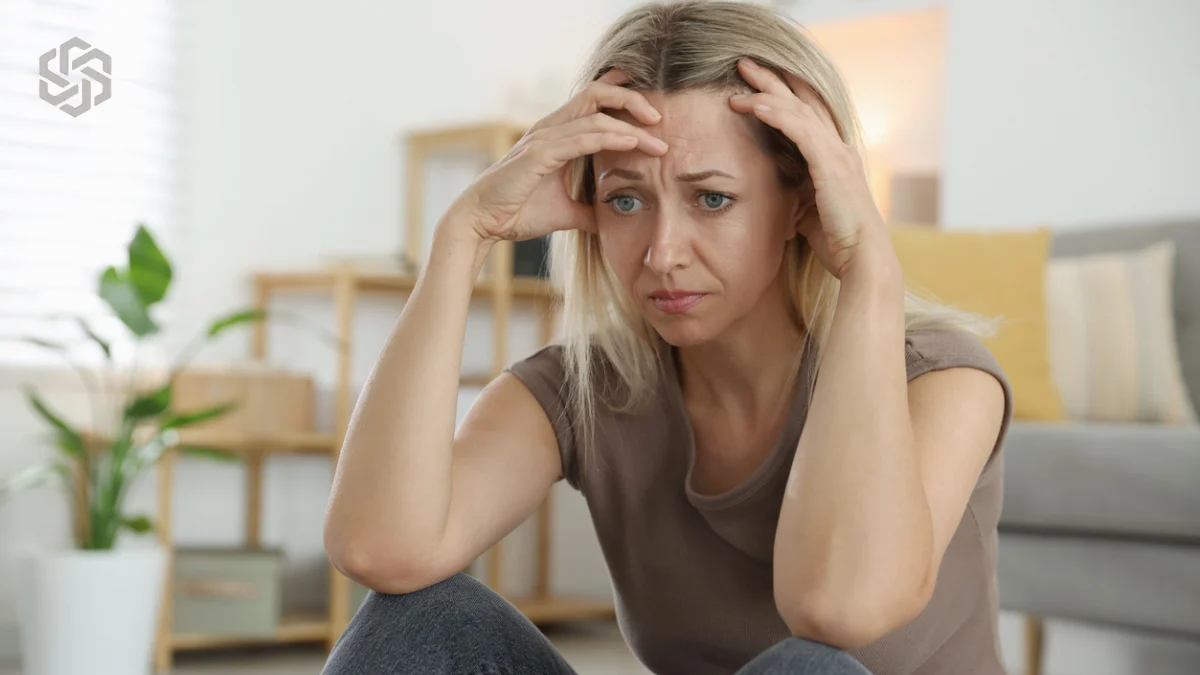Woman holding her head in frustration at home