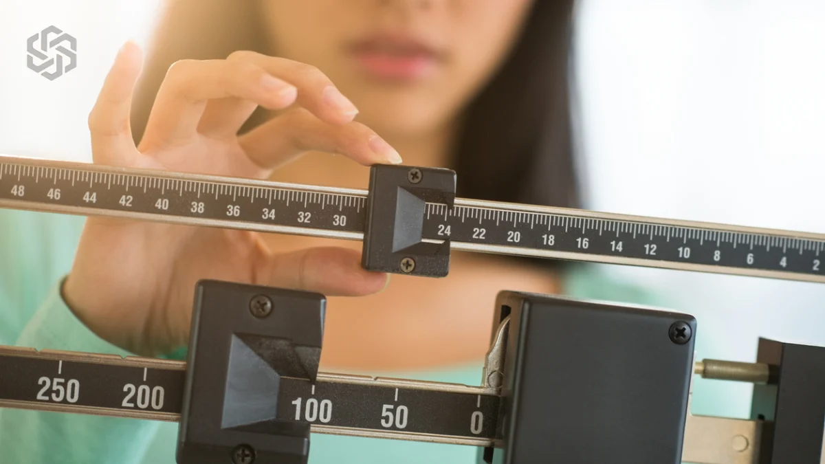 Woman adjusting a medical weight scale