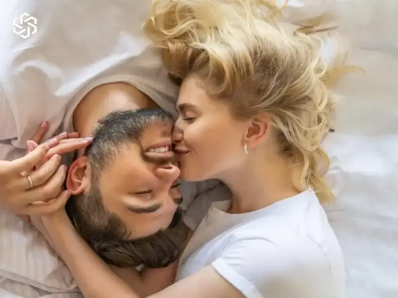 Affectionate couple lying close together in bed