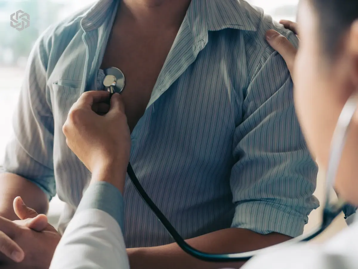 Provider listening to a patient’s chest with a stethoscope during a primary care & prevention visit