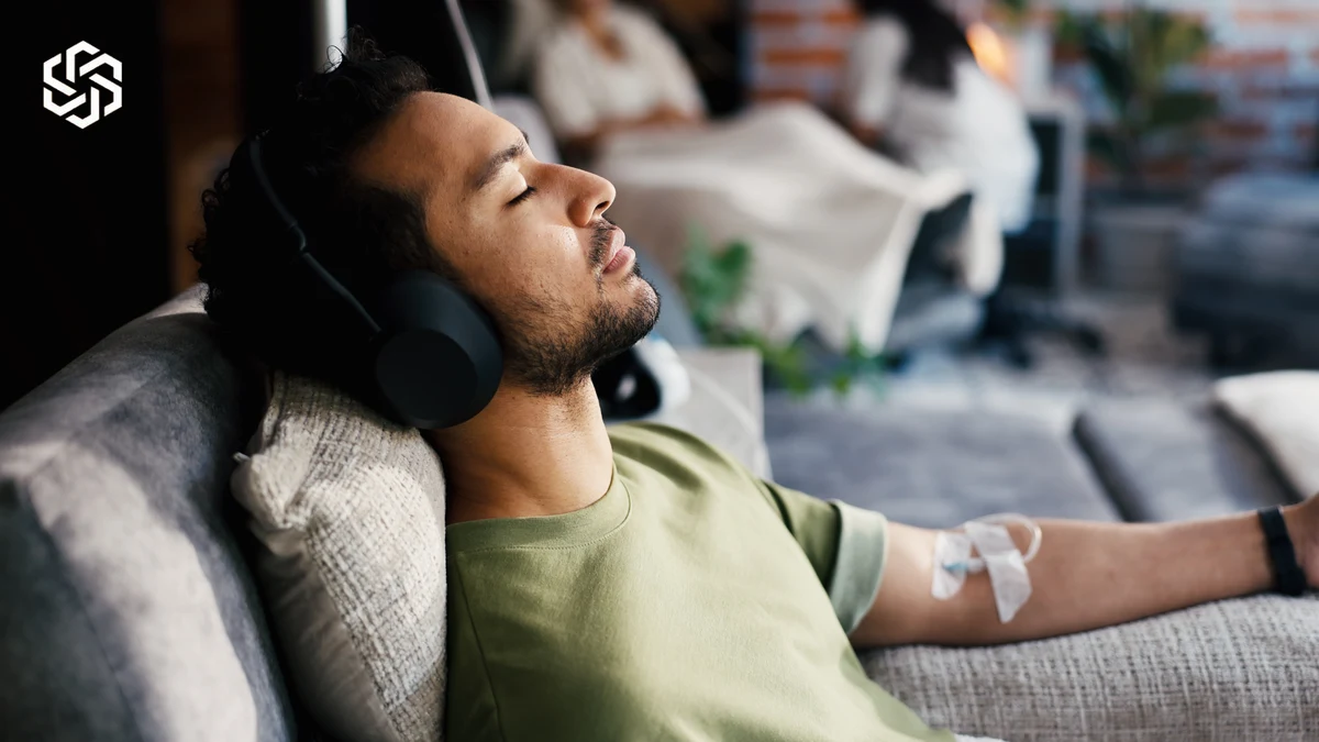 Man relaxing with headphones during an IV infusion