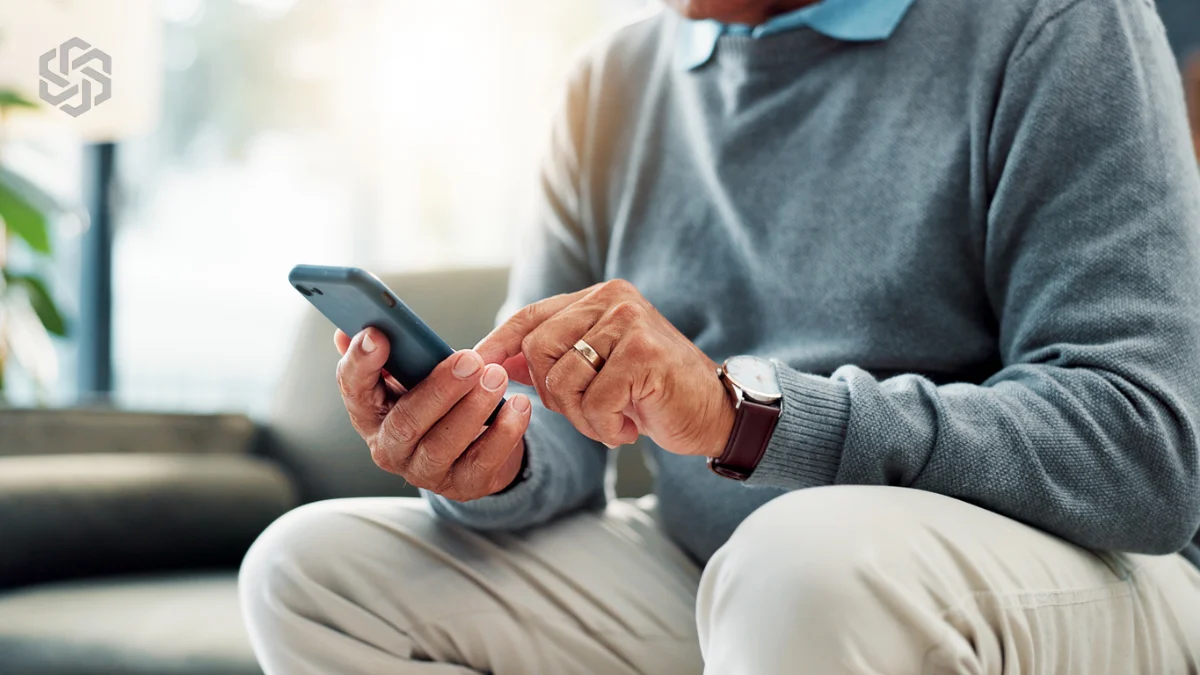 Older man using a smartphone at home