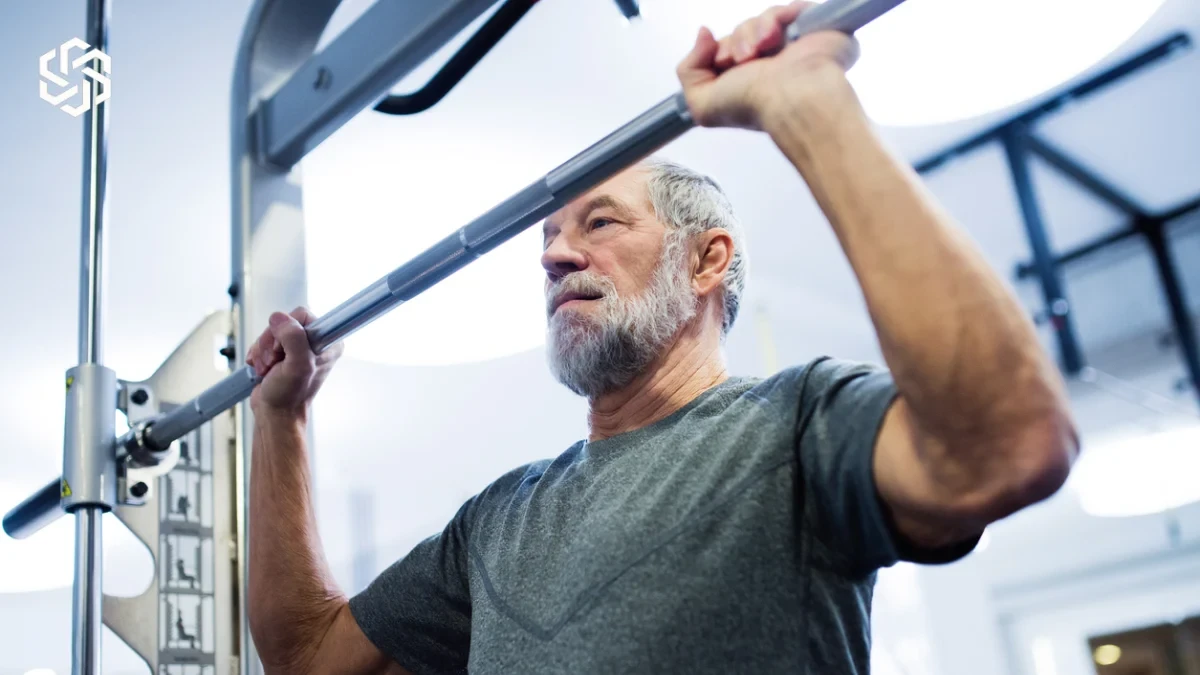 Older man doing pull-ups at the gym