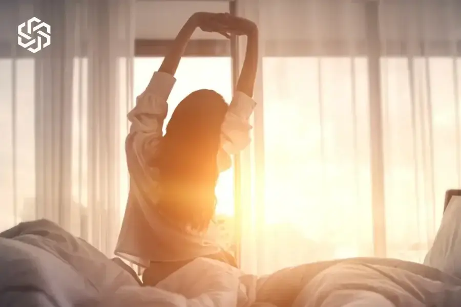 Woman stretching in bed after waking up