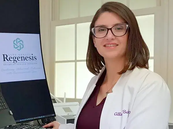 Allana Bush, FNP-C, smiling at her desk at Lake Forest Regenesis in Lake Forest, IL