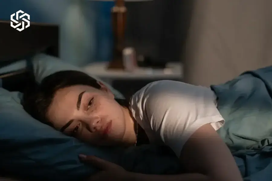 Woman lying awake in bed at night