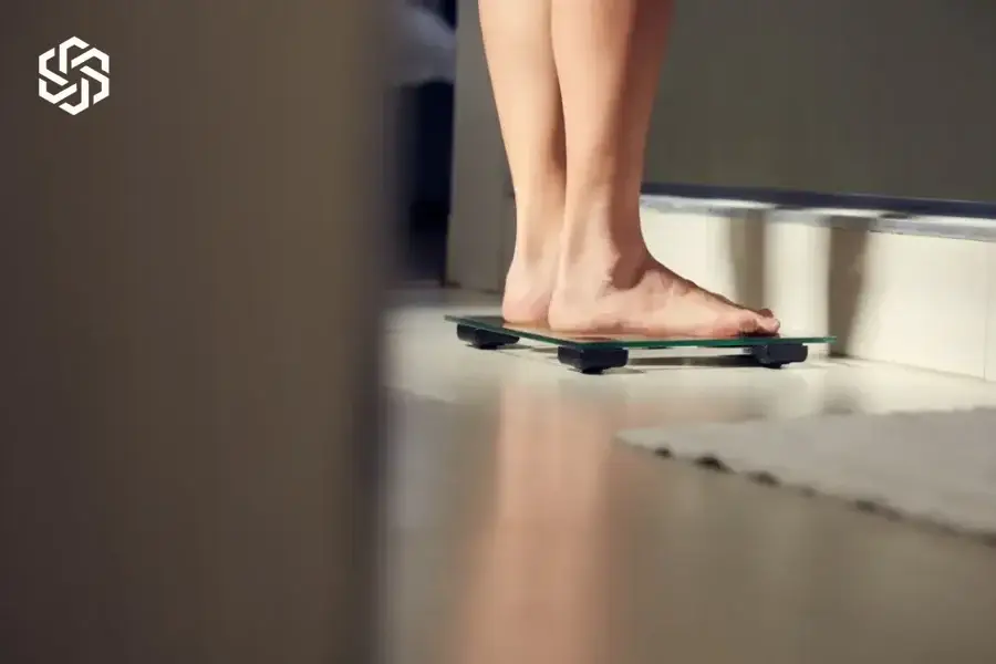 Woman stepping onto a bathroom scale