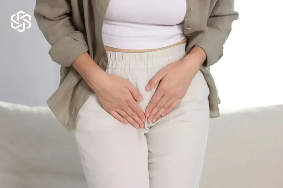 Woman pressing her hands over her lower abdomen with urinary discomfort
