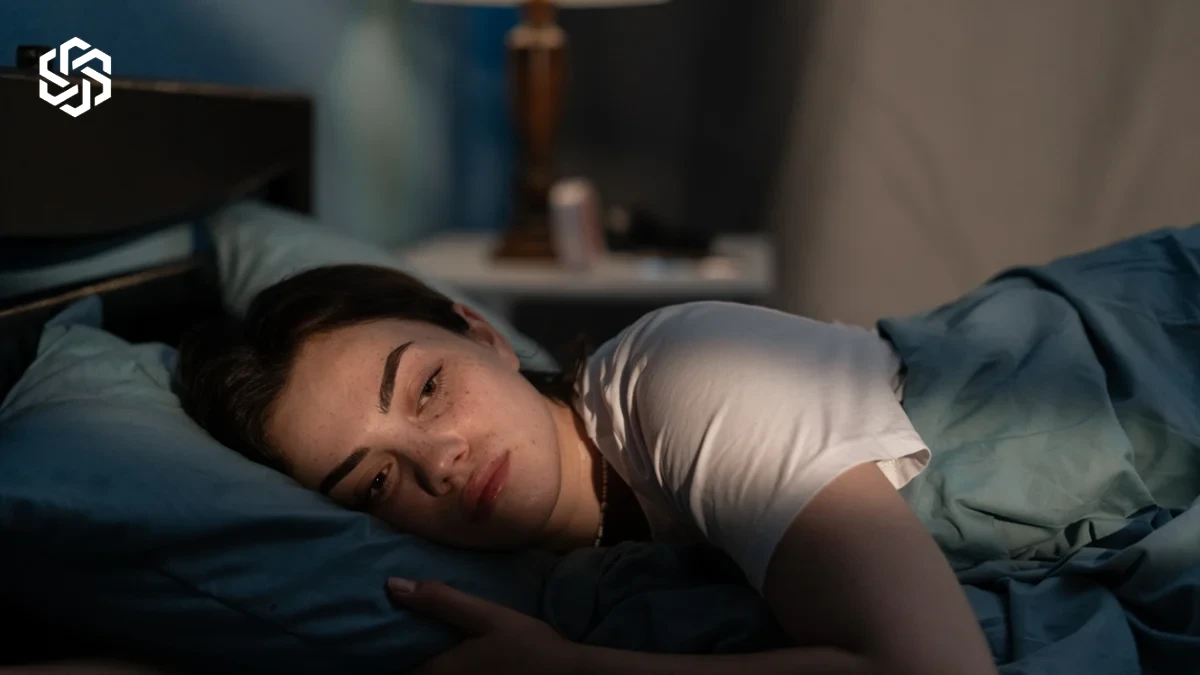 Woman lying awake in bed at night, having trouble sleeping